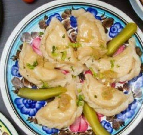Pierogi with onion on folk plates